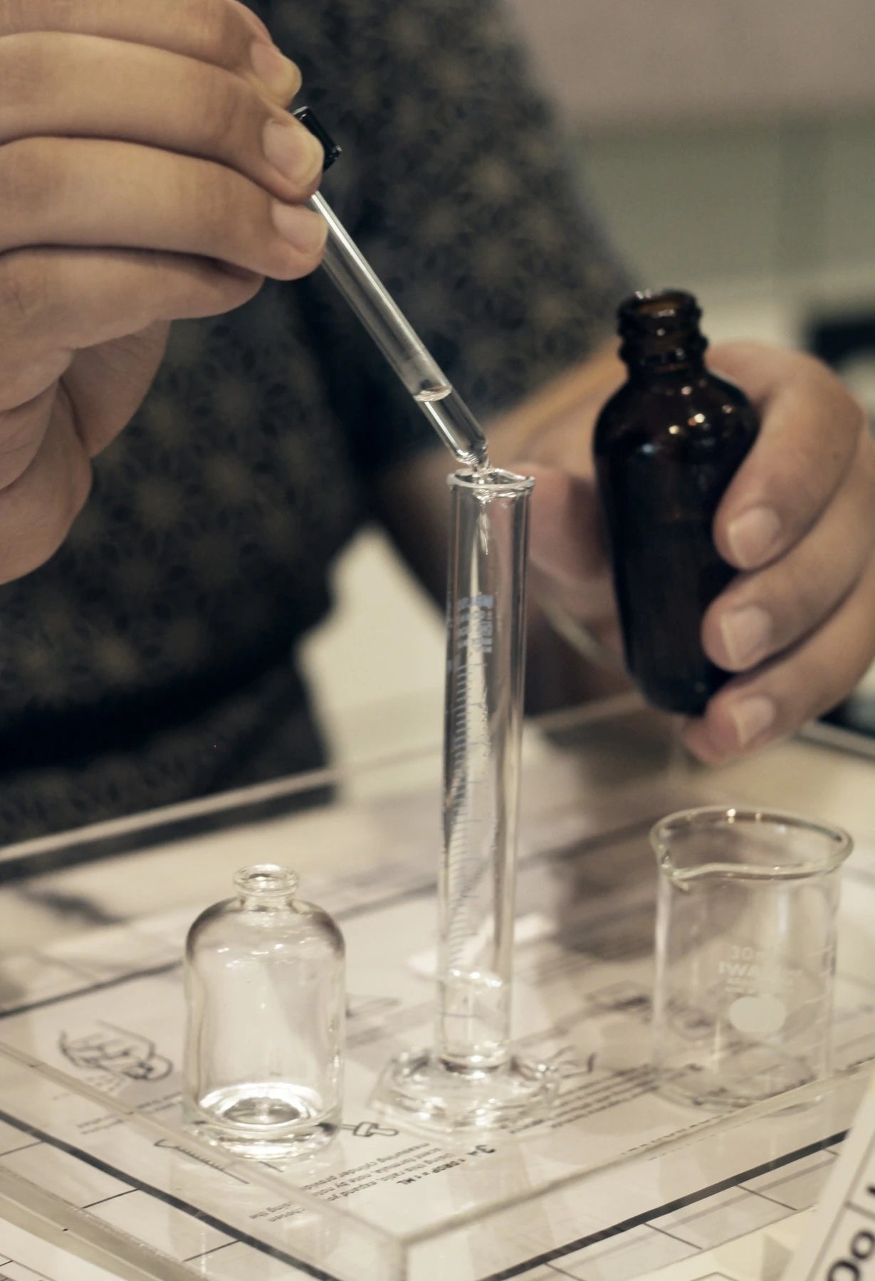 Hands exploring fragrance at the Oo La Lab mixing bench